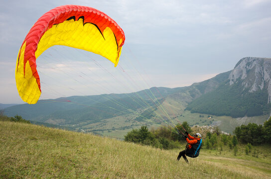Paraglider raising his canopy to take flight