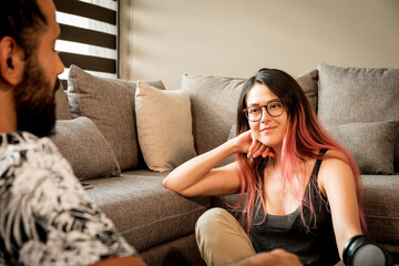 Fototapeta premium Joven pareja mexicana platica en casa relajada sonriente sillon atardecer