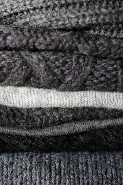 A Close Up Of A Pile Of Gray Winter Knit Sweaters