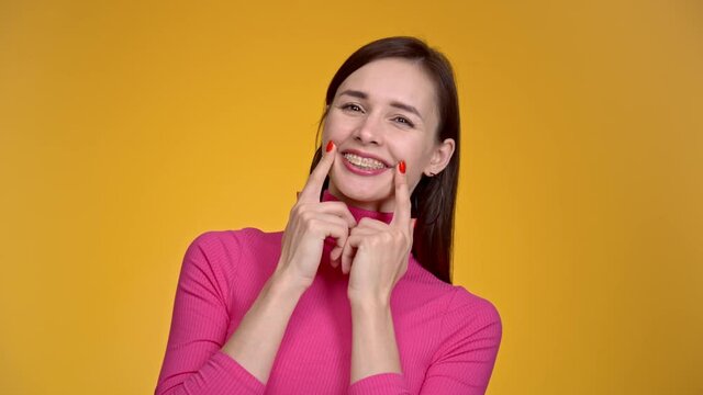 Young joyful woman with braces on her teeth.