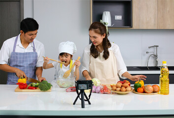 Happy family cooking together on kitchen,Happy family with little chef cooking indoor with live streaming online