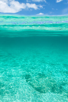 Emty half turquoise tropical sea water half blue sky background