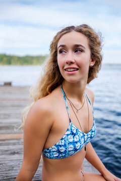 Beautiful young woman wearing bikini on the lakeside