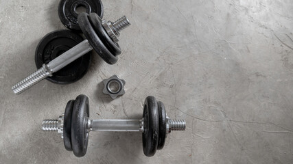 Obraz na płótnie Canvas Steel dumbbells on the cement floor in the gym For bodybuilders