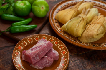 Tamales mexicanos hoja de maiz salsa tomatillo verde picantes chile carne de cerdo platillo latino ingredientes envuelto relleno ancestral tradiciones día de muertos candelaria