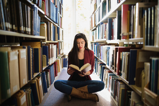 Young asian woman reading in library
