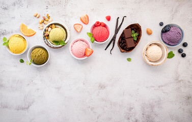Obraz na płótnie Canvas Various of ice cream flavours in bowl blueberry ,green tea ,coconut ,strawberry and chocolate setup on white stone background .