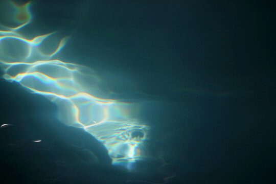 A Patch Of Sunlight Hitting A Pool Of Dark Blue Water