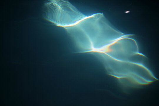 An Abstract Patch Of Sunlight Hitting A Pool Of Dark Blue Water Creating A Rainblow