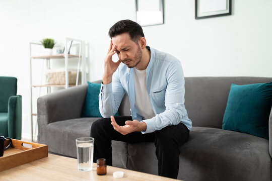 Young man taking pills for a headache