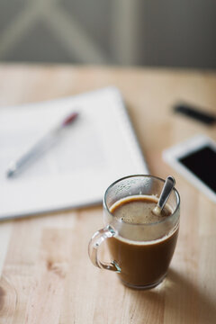 Studing at the table in front of coffee and milk glass mug