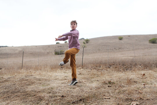 Boy Doing Pirouette In Empty Field
