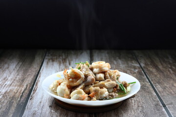 Fried and stirred fresh peeled shrimp, chopped chicken thigh, chilly and spring onion on the plate. Hot and spicy street food menu in Asia. 
