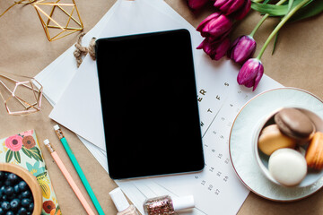 A smart touch tablet on a table with a calendar