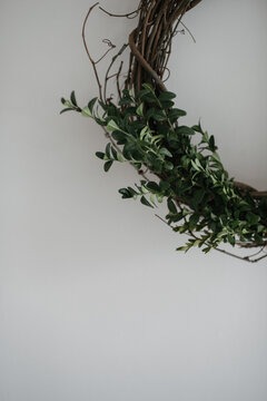 Simple diy boxwood holiday Christmas wreath on white wall