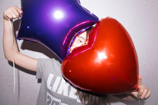 Young woman looking out of two balloons