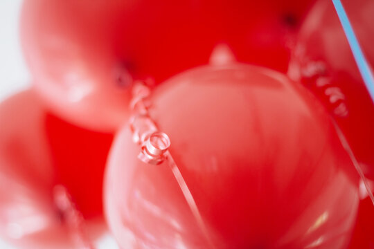 Bunch of red balloons with red strings closeup