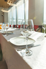 Empty glasses set in restaurant.Served for a banquet table.detail of a dining table set up with wine glasses.Served holiday table, cutlery, crockery, glasses, plate, forks on white table.catering
