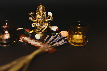Table with occult attributes, top view. Ganesha figurine, stone rosaries, candles, aroma stick