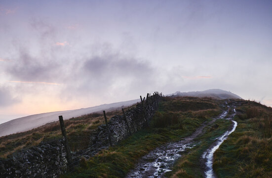Mountain path and fence at sunset. Derbyshire, UK.
