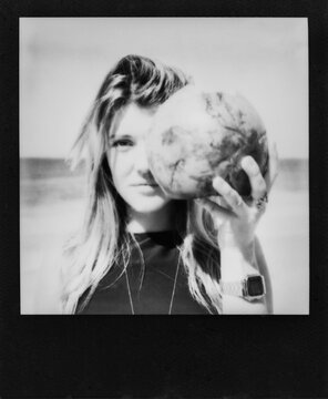 Black and White Polaroid of Young Woman Holding Coconut in Front of Face