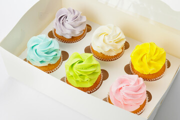 Box with tasty cupcakes on white background