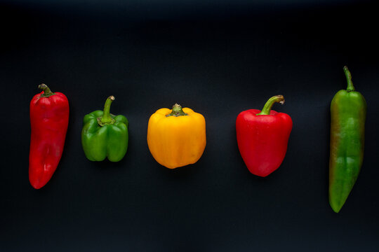 Various types of peppers on a black background