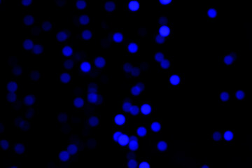 Blurry colored Christmas holiday lights on a black background.