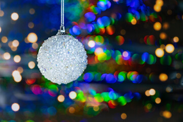 An ornament on a background of multicolored blurred Christmas lights