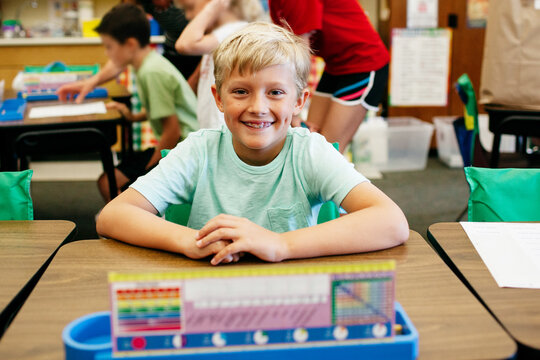 smiling student sitting at his desk