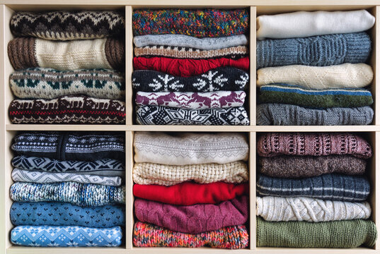 Winter-themed sweaters arranged on a shelf