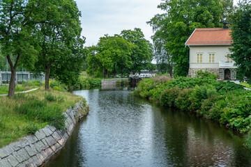 Fototapeta na wymiar Lush green summer view of a sluice or lock gate at the stromsholms canal in Sweden