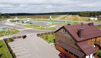 Top view of suburban cottages and houses. Near green summer fields