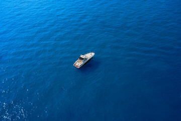 White large yacht anchored anchored on blue water. Travel - image. Yacht in the rays of the sun on blue water.