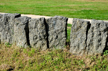 Separation of the park from the road by a series of granite columns of menhirs or bollards which...