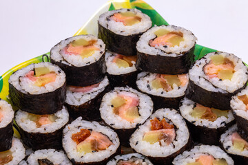 Top view of stack of Japanese sushi maki roll plate. Served in Japanese bar restaurant with chopstick