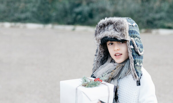 Boy in a warm cap and a festive present box