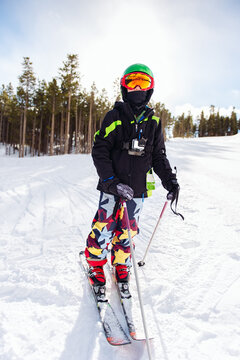 Boy in ski clothes and skis on a ski slope in morning light