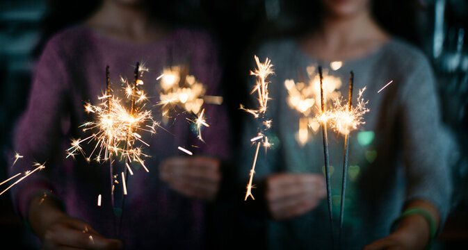 2 different photos mirrored to each other, this way twin girls holding heart shaped bokeh sparklers