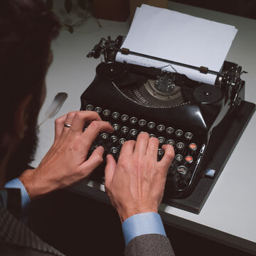 Man typing with a vintage typewriter