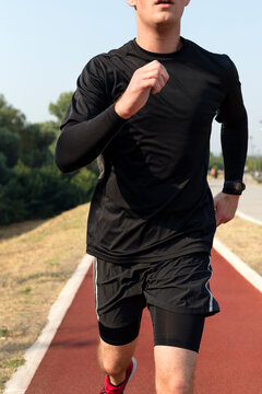 Man running towards the camera on the track outdoor
