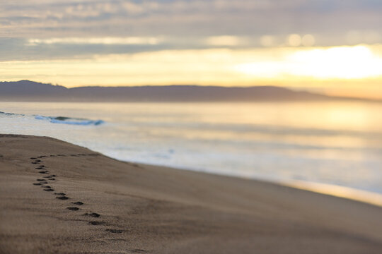 Footsteps on the beach at sunset
