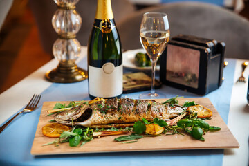 Roasted sea bass with herbs on the served table