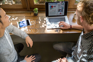 Two man discussing a project and looking at the computer to check data