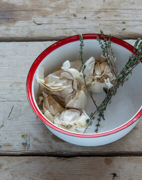 Heads of garlic with thyme in a bowl