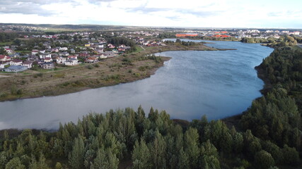 Top view of suburban cottages and houses near a large summer lake