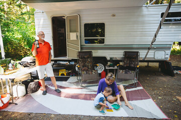 Grandparents hanging out in campsite with grandosn