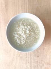 Porridge or boiled rice in a white bowl. select focus
