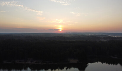 Beautiful sunrise over calm lake and forest