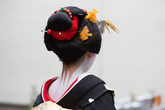 A traditional geisha out and about walking in Gion Kyoto Japan .